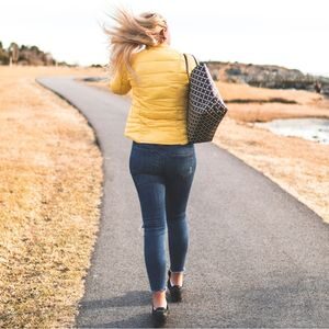 Woman in yellow jacket walking on paved path