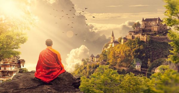 Monk meditating on a mountain top